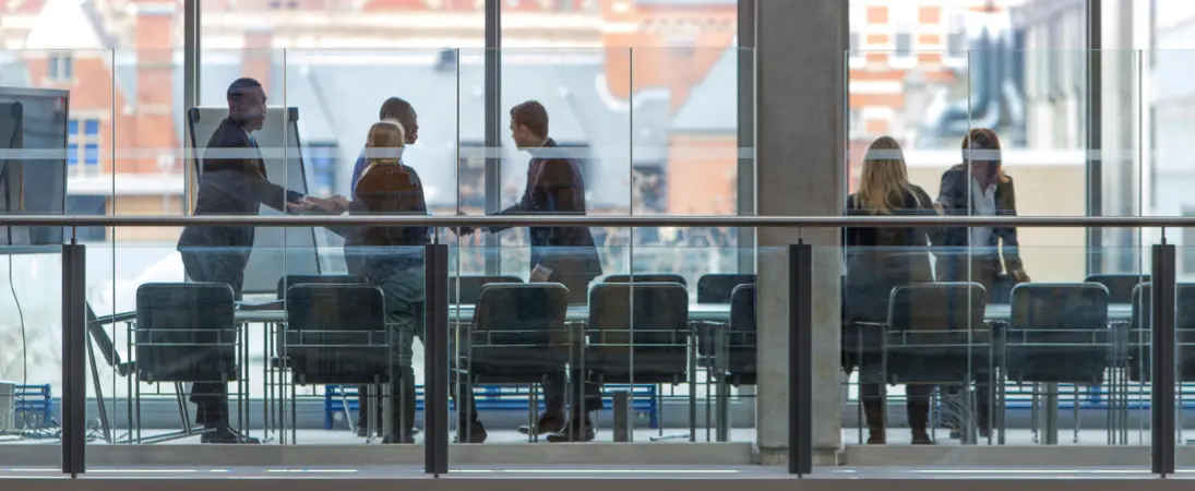 business professionals in a glass boardroom meeting complex commercial litigation